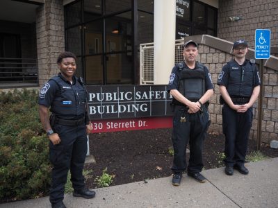 Security officers Nicole Pendergast, Brinson Kinzer, and Hunter Cochran stand outside the Public Safety building