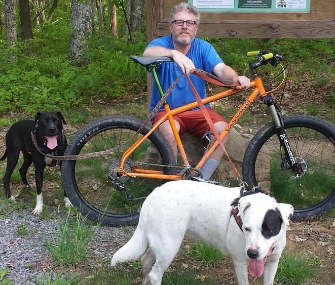 Buzz Johnson posed on bike with his two dogs